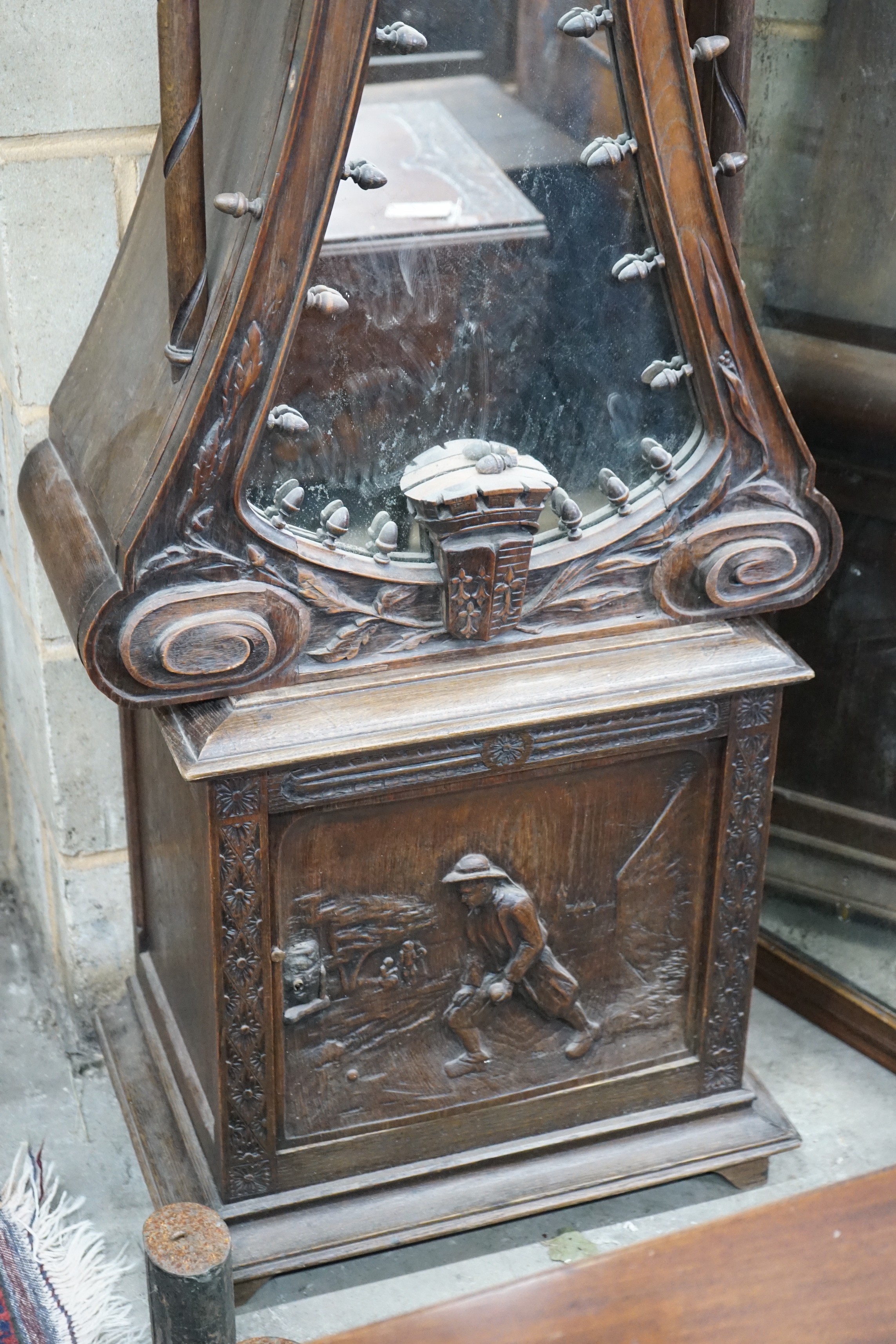 An early 20th century Flemish carved oak and walnut longcase clock, height 240cms.